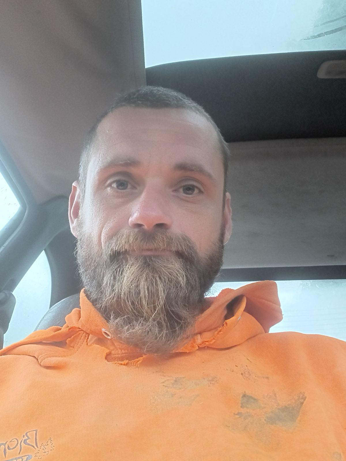 Crew member of Bieniek Tree Service wearing an orange hoodie, showcasing a professional appearance and readiness for tree care services.